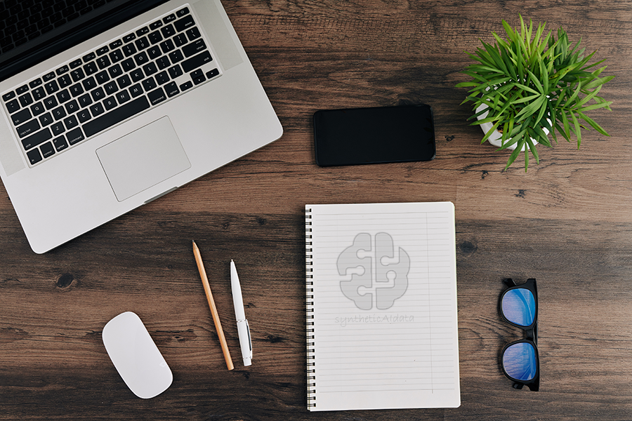 A desk with a laptop, mouse, phone, glasses and a notebook with syntheticAIdata written on it A desk with a laptop, mouse, phone, glasses and a notebook with syntheticAIdata written on it